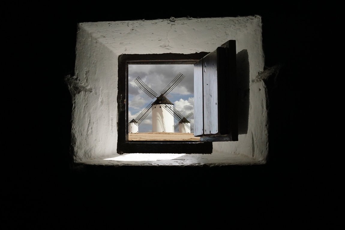 Molinos de Castilla-La Mancha vistos a través de una ventana.